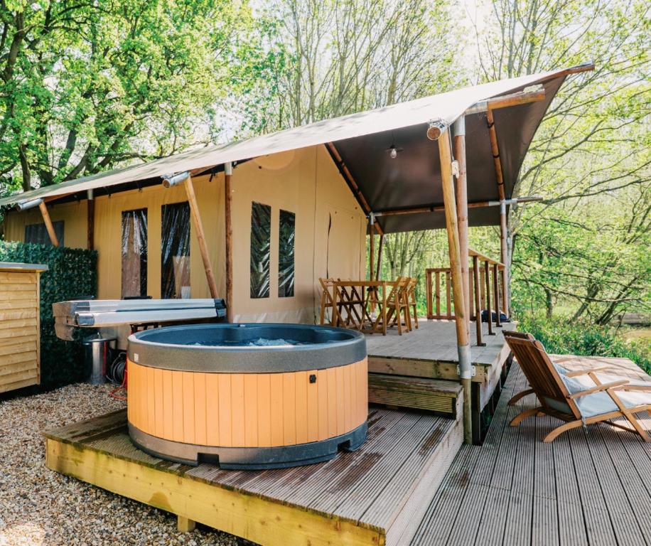 a hot tub on the deck of a house at Kingfisher Safari Tent in Droitwich