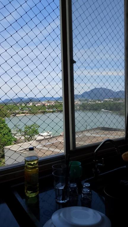 a window with a view of a body of water at Edifício thorium in Guarapari