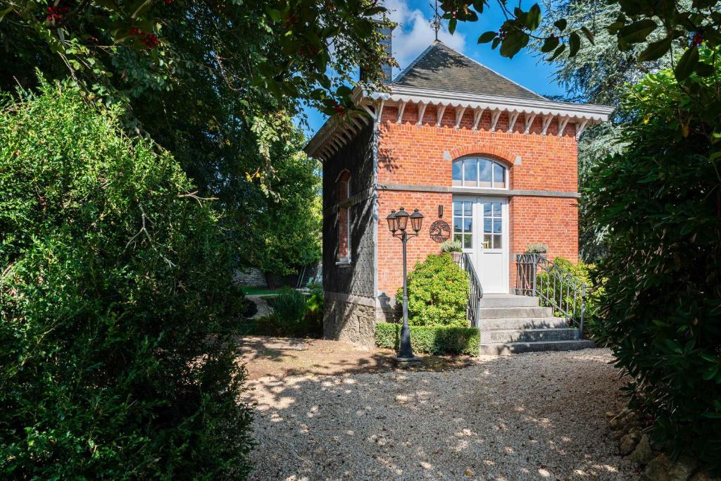 un edificio de ladrillo rojo con ventana y escaleras en Le Parc de Louette - Le Pavillon - Esc'Appart, en Gedinne