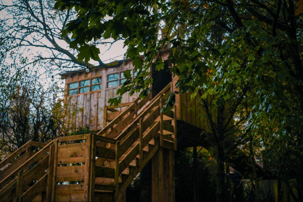 un puente de madera con un edificio de fondo en The Treehouse Hideaway, 