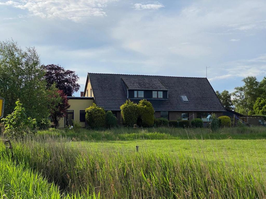 a house with a green field in front of it at In't Noord Kombüse in Stick