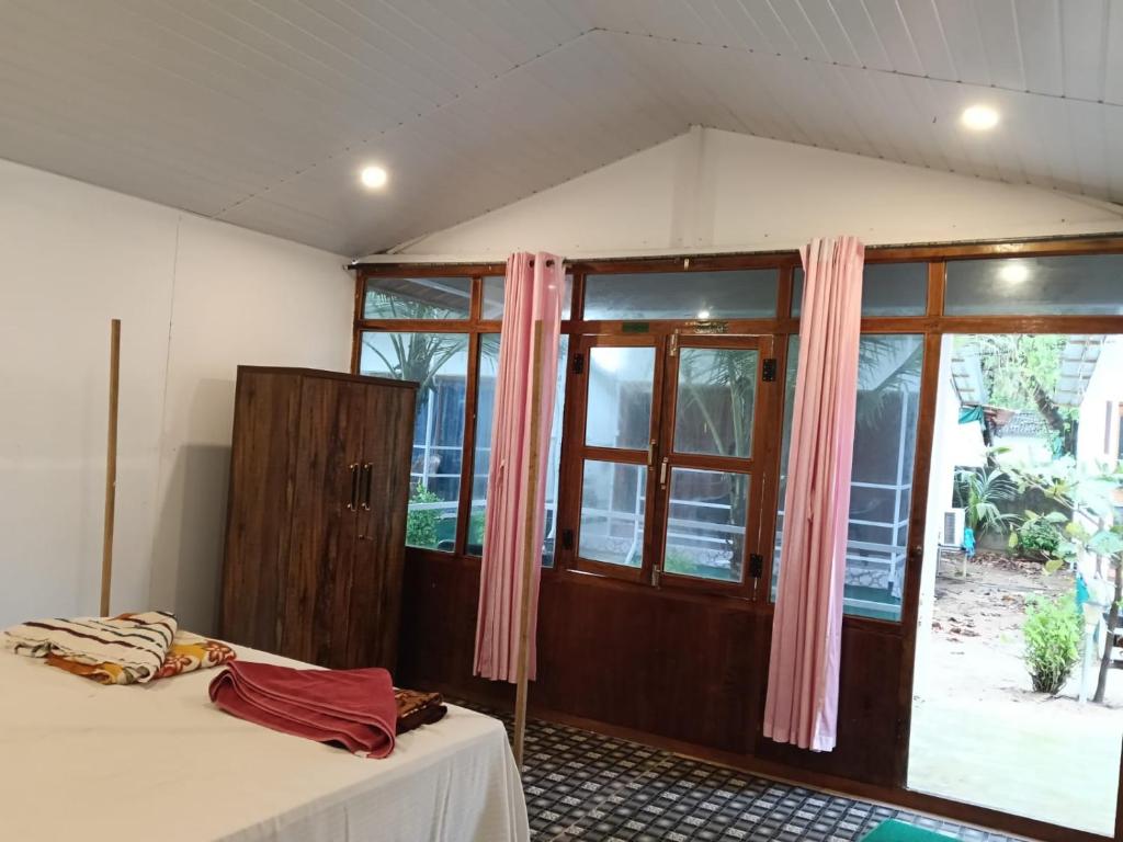 a room with a bed and a large window at Mountain Palm patnem beach in Patnem