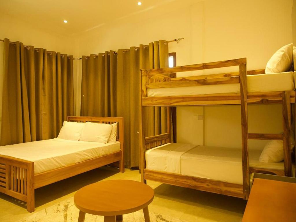ein Schlafzimmer mit zwei Etagenbetten und einem Tisch in der Unterkunft Mkunazini Heritage Hostels in Zanzibar City