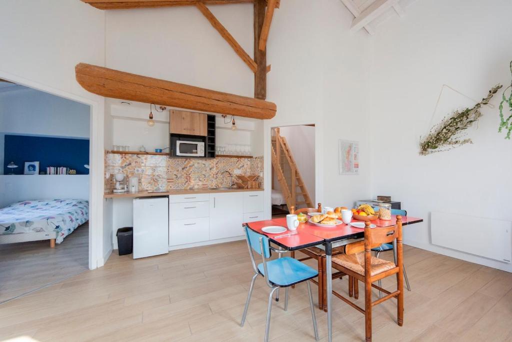 Una cocina y un comedor con mesa y sillas. en Nature and vue imprenable, en Ouroux