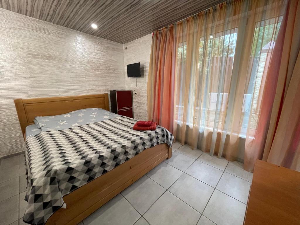 a bedroom with a bed and a large window at House&House 84 in Petropavlovskaya Borshchagovka