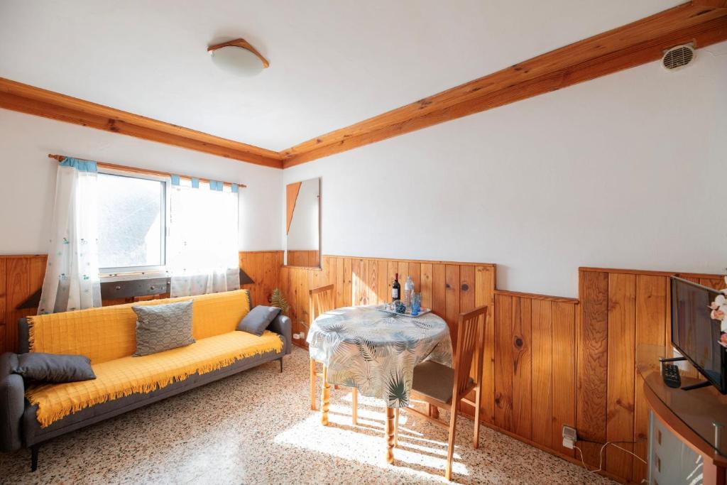 a living room with a yellow couch and a table at Refugio con encanto en la Gomera con vistas a las montañas in Arure