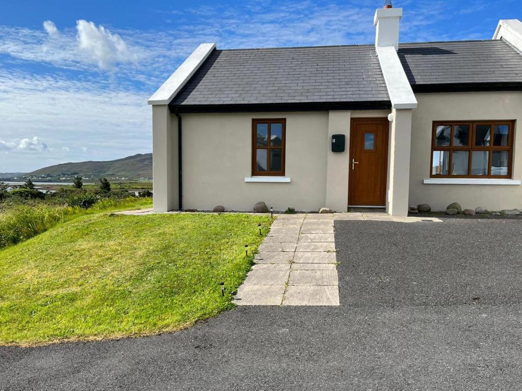une petite maison blanche avec une allée en face de celle-ci dans l'établissement Holiday Home Achill Sound Holiday Village No 11 by Interhome, à Achill Sound