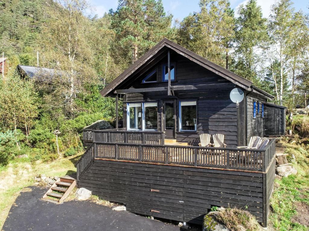 a cabin in the woods with chairs on a deck at Holiday Home Kosestua by Interhome in Madland