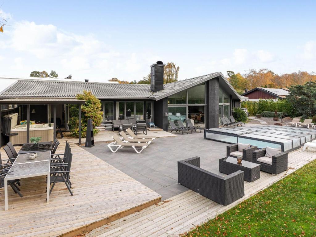 an outdoor deck with furniture and a house at Villa Frösakull Paradiset by Interhome in Frösakull