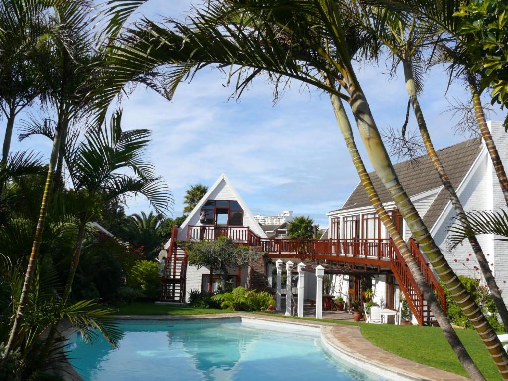 a house with a swimming pool and palm trees at Aberdour Guesthouse in Port Elizabeth