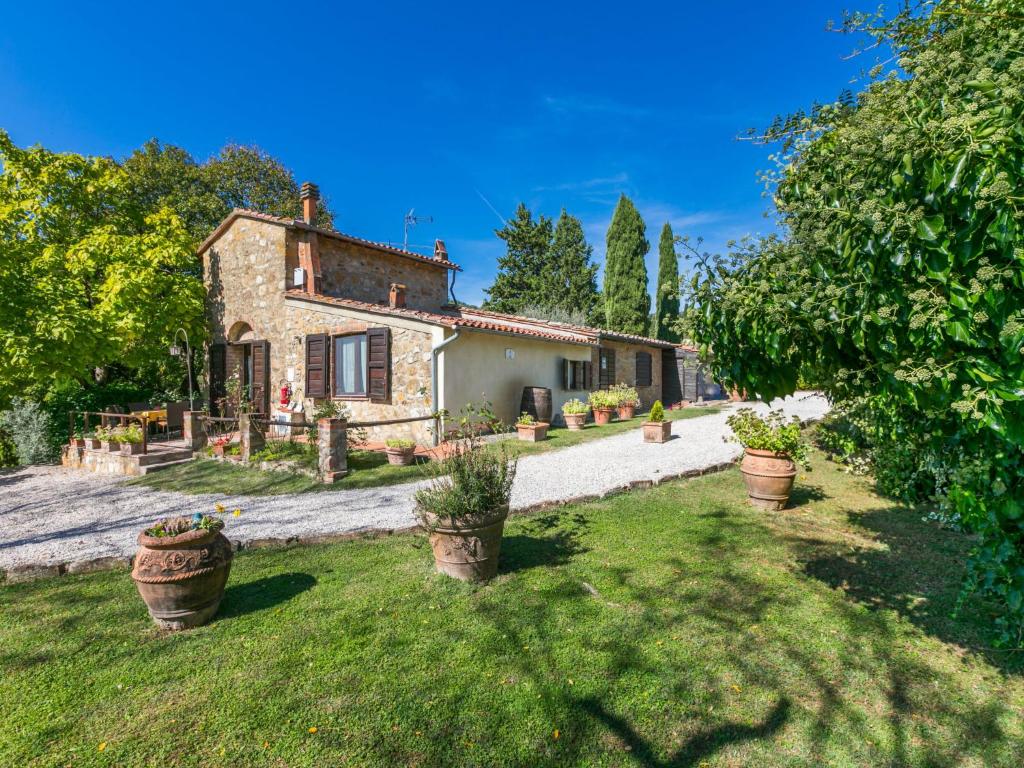 une vieille maison en pierre avec des plantes en pot dans une cour dans l'établissement Holiday Home Geranio by Interhome, à Trequanda