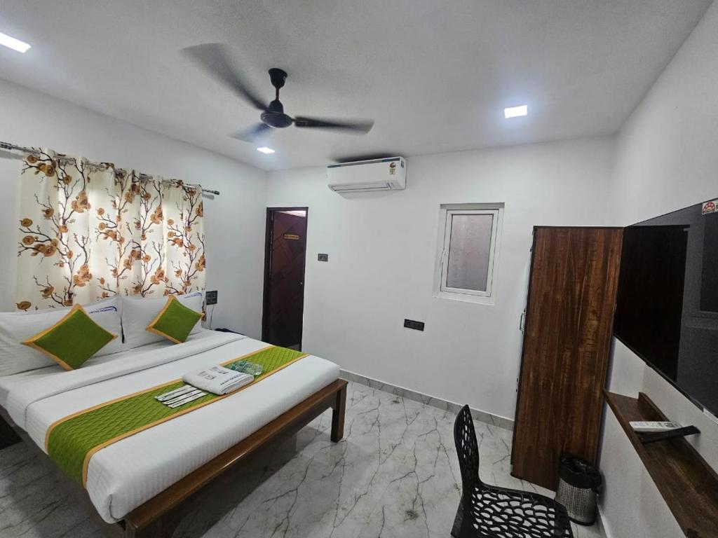 a bedroom with a bed and a ceiling fan at MetroResidency com in Chennai