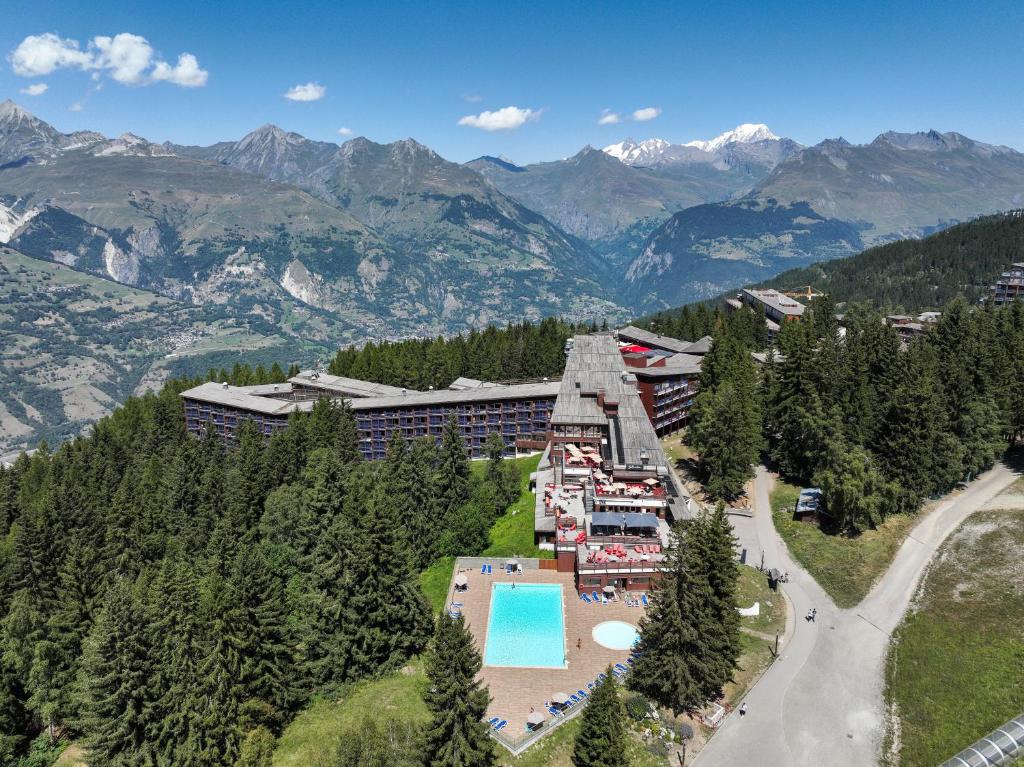 an aerial view of a resort with a swimming pool and mountains at Belambra Clubs Arc 1800 - Hôtel Du Golf in Arc 1800