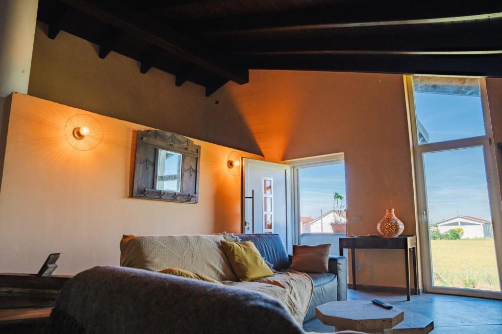 a living room with a couch and a large window at Guest House dei Cavalli in Lobbi