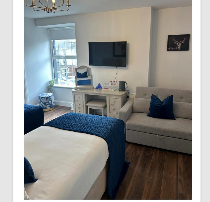 a bedroom with a bed and a desk and a couch at Auld Shebeen in Moate