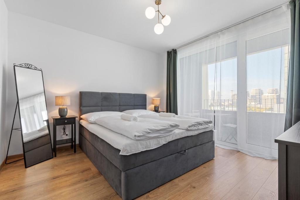 a bedroom with a large bed and a large window at LAM Discovery AC - Balcony in Bratislava