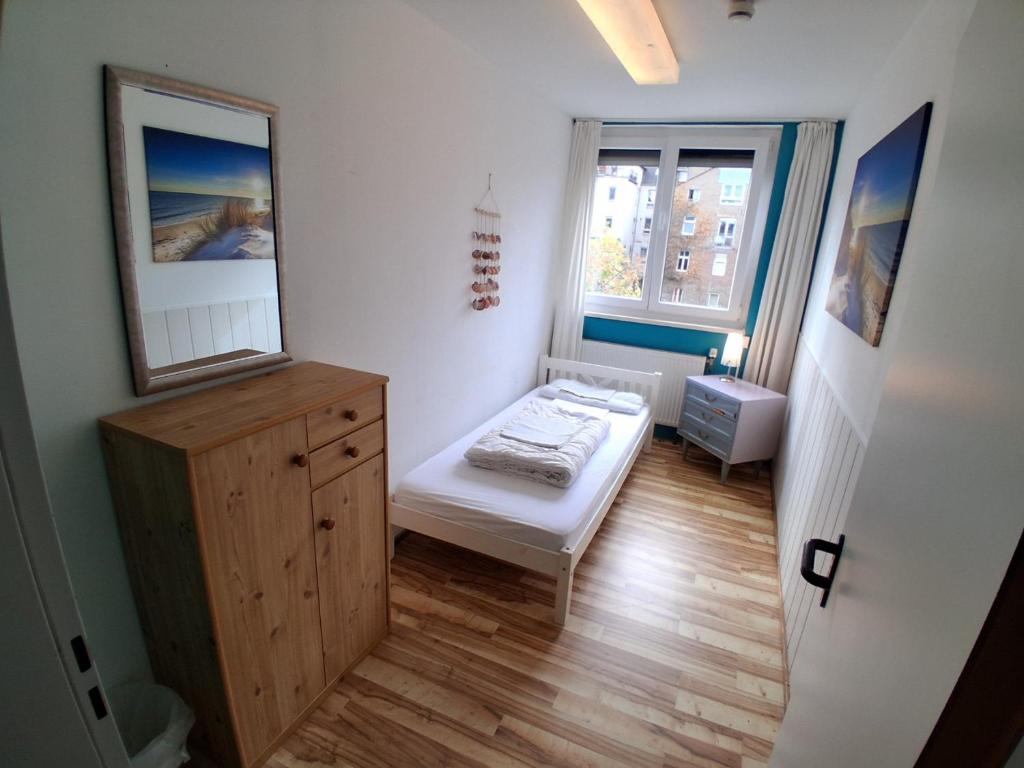 a small room with a bed and a mirror at Max Hostel in Bonn