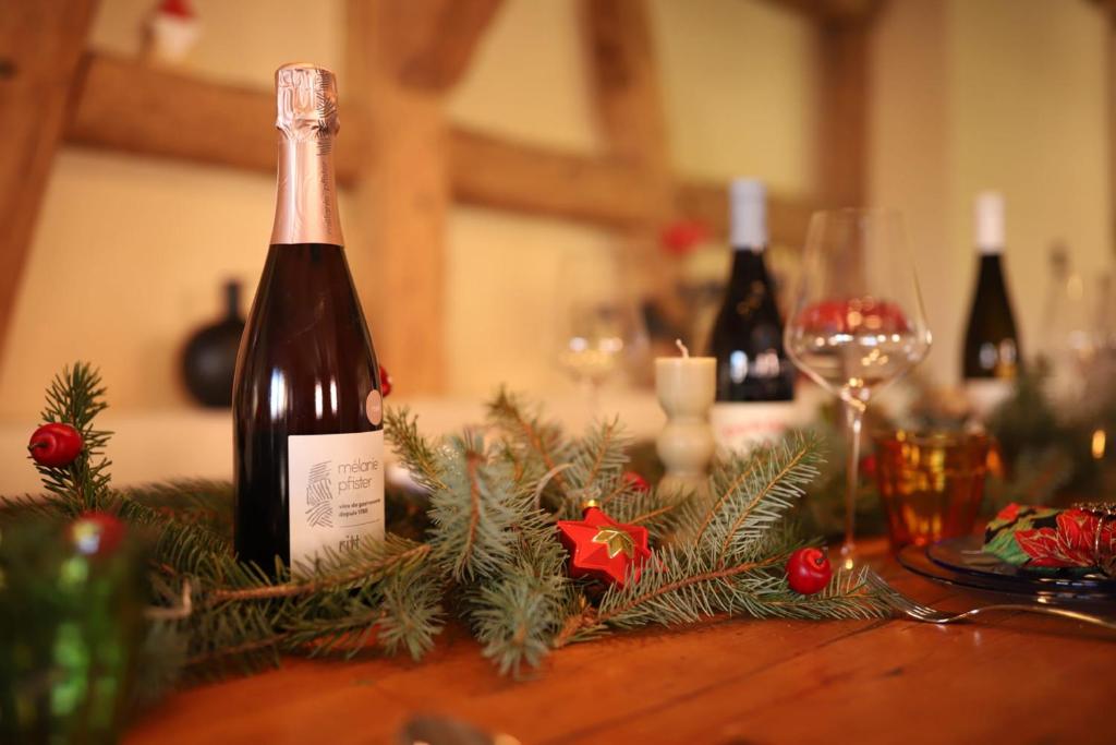 a bottle of wine on a table with christmas decorations at The Gîte 1848 the charm of new in the old in Hangenbieten
