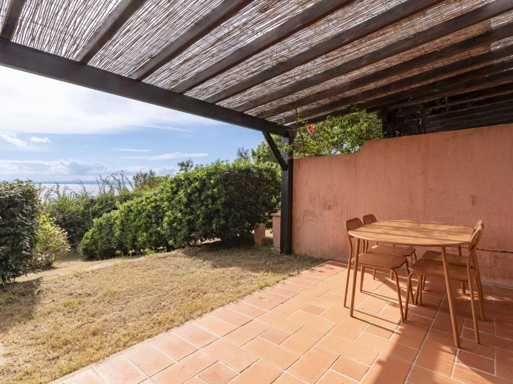 ein Holztisch und Stühle auf einer Terrasse in der Unterkunft Holiday Home Villa 12 by Interhome in SantʼAmanza