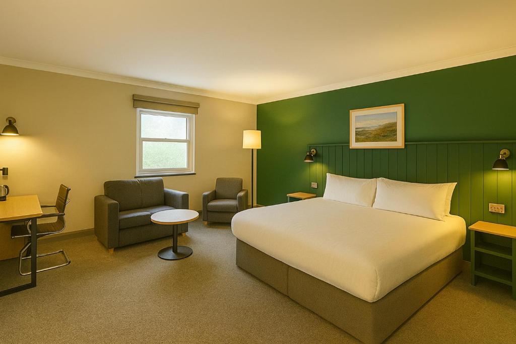 バーミンガムにあるPairc House Hotelのベッドと椅子のあるホテルの部屋