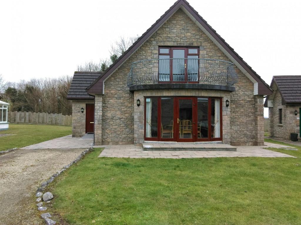 a brick house with a balcony on top of it at Holiday Home Galway Bay - TR4Lodge by Interhome in Doughiska