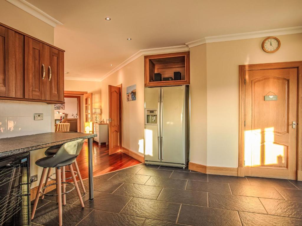 a kitchen with a counter and a refrigerator at Holiday Home Benderloch House & Frobost Lodge by Interhome in Daliburgh