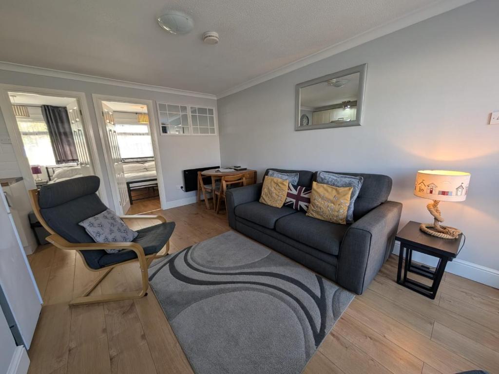 a living room with a couch and a chair at 194, Belle Aire, Hemsby - Two bed recently renovated chalet, sleeps 4, pet friendly, free Wi-Fi and bed linen and towels included in Hemsby