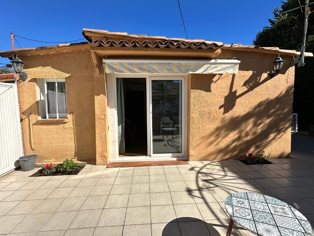 a house with a patio with a sliding glass door at Petite maison indépendante in Cagnes-sur-Mer
