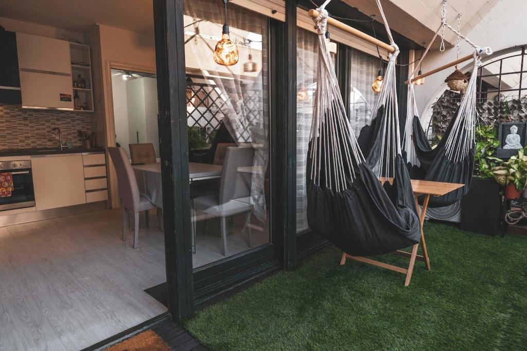 een kamer met twee hangmatten en een eetkamer bij Il Nido dei Cigni in Desenzano del Garda