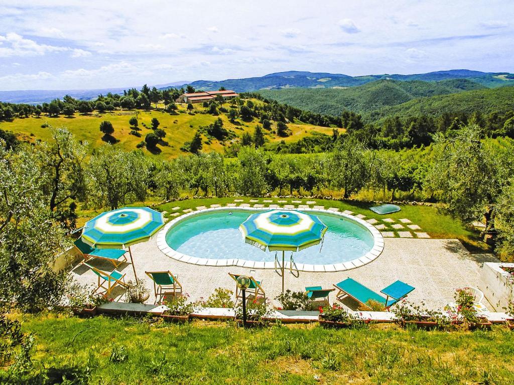 an outdoor swimming pool with umbrellas and chairs at Apartment Cielo Terra by Interhome in Gambassi Terme