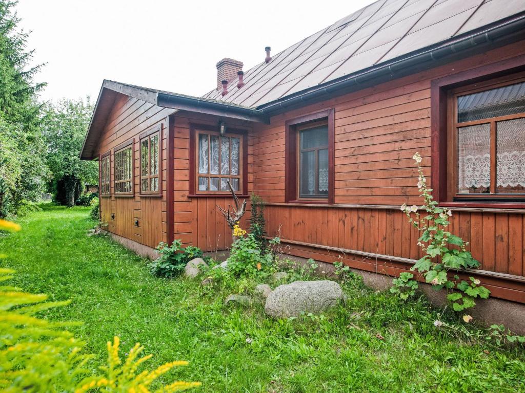 a small wooden house with a green yard at Apartment Kalina by Interhome in Stoczek