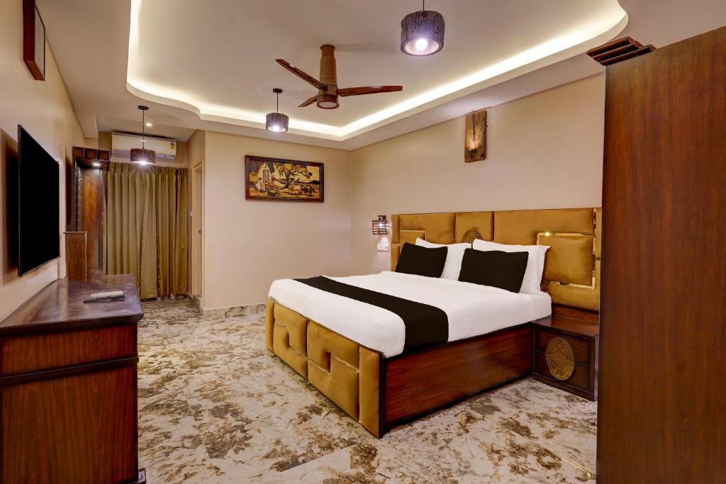 a bedroom with a bed and a dresser in it at Super Townhouse NK Vivanta Luxury Rooms in Chennai