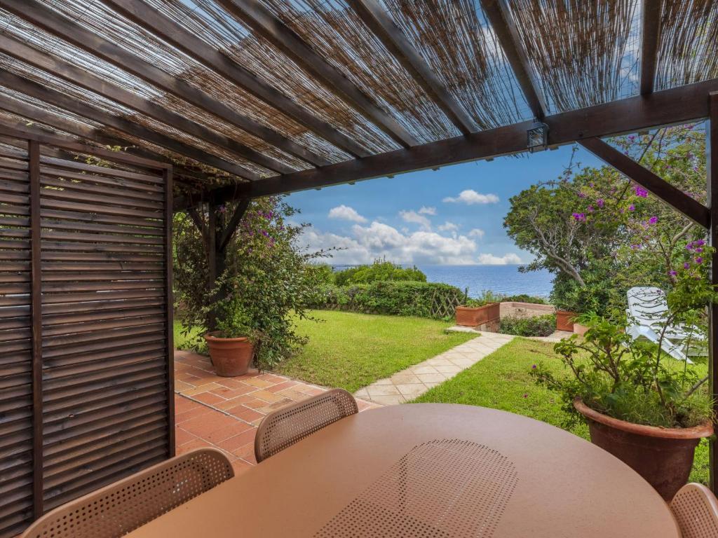 ein Tisch und Stühle auf einer Terrasse mit Blick auf das Meer in der Unterkunft Holiday Home Villa 19 by Interhome in SantʼAmanza