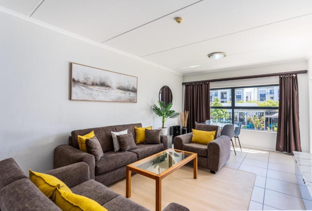 una sala de estar con un sofá y una mesa en The Sandown 178 by CTHA, en Parklands