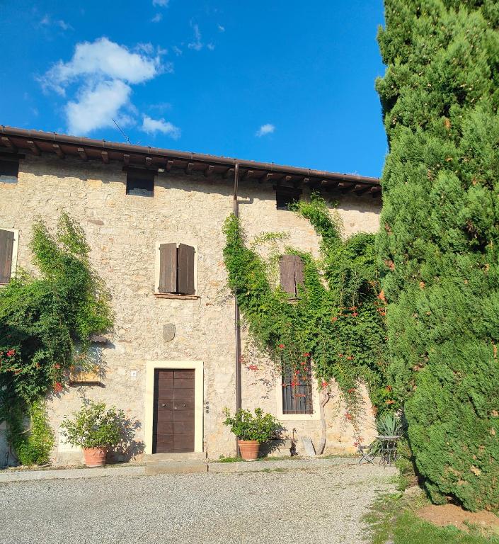 a large brick building with a door and a tree at Antico N19 in Passirano