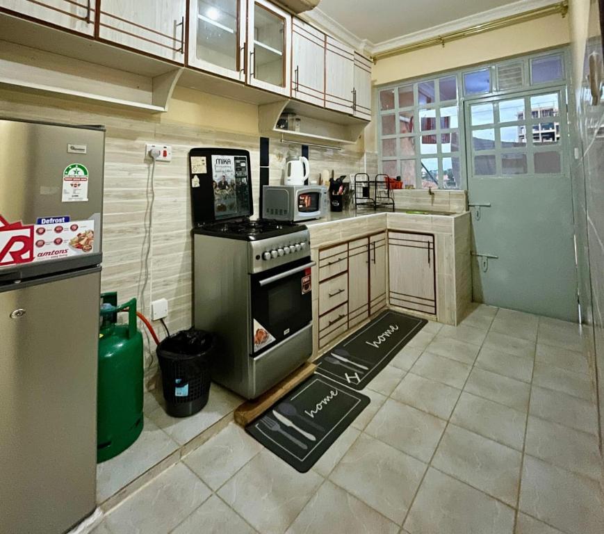 a kitchen with a stove and a refrigerator at Eldoret Cozy Homes - Pioneer in Eldoret