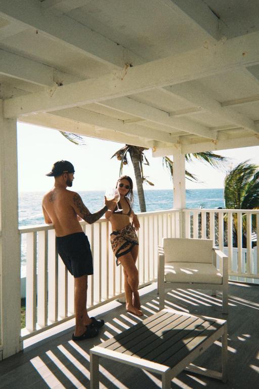 a man and a woman standing on a porch at Danielas Beachfront House in Rincon