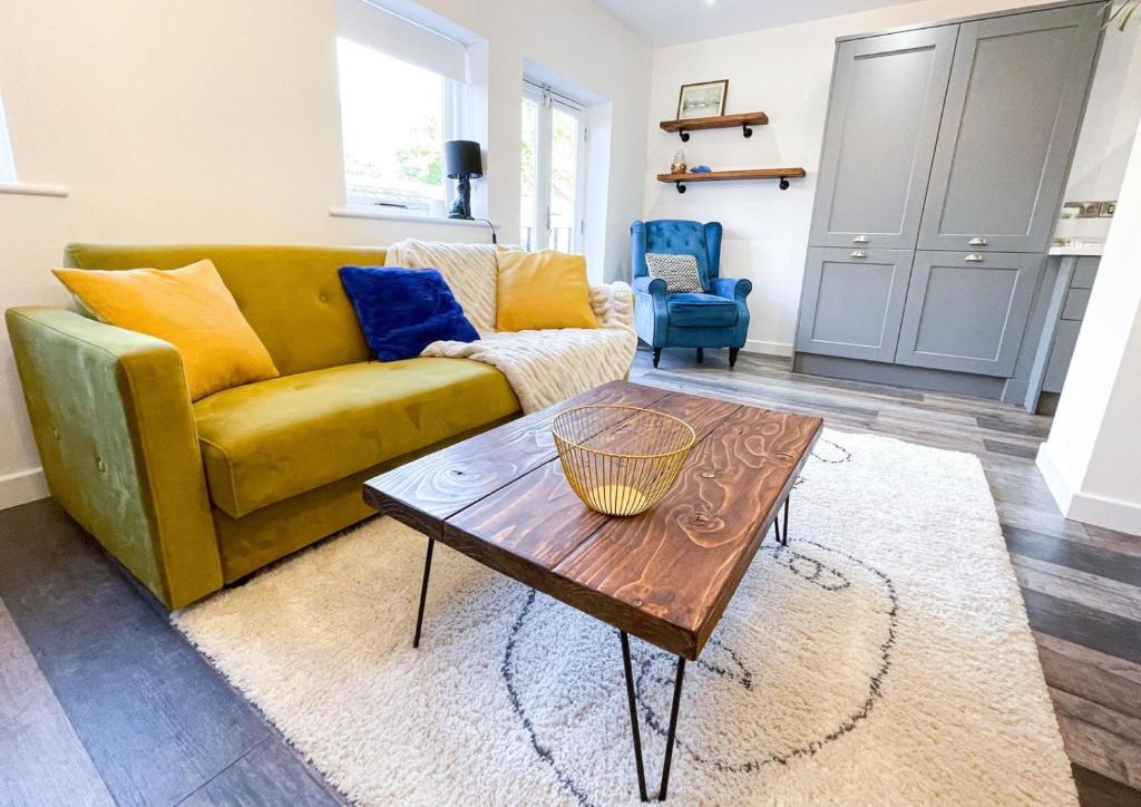 a living room with a yellow couch and a coffee table at New! 1BR in Horsemarket in Darlington