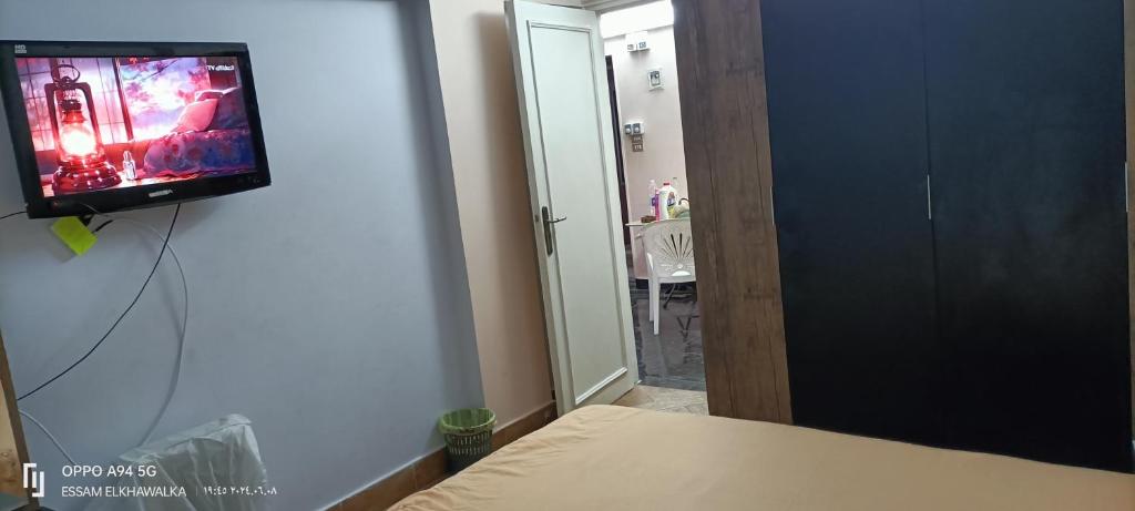 ein Schlafzimmer mit einem Flachbildfernseher an der Wand in der Unterkunft Alexandria Egypt in Alexandria