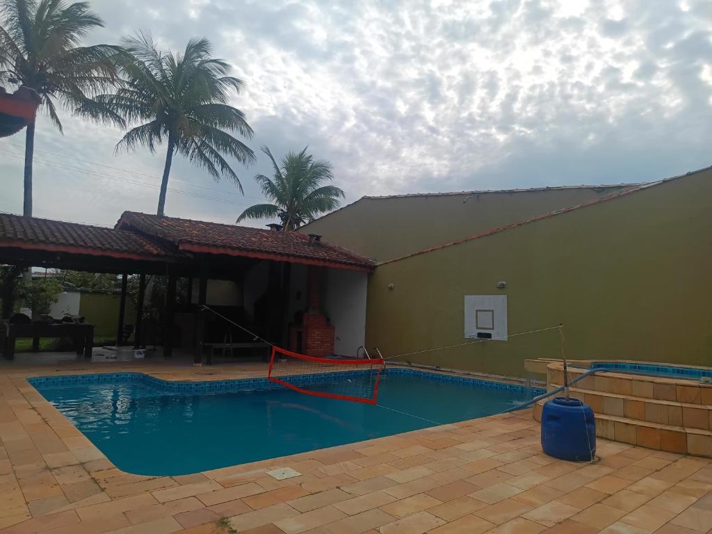 una piscina con un aro de baloncesto junto a un edificio en Paz, en Peruíbe