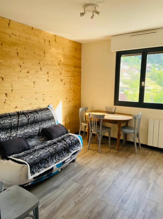 a room with a bed and a table with chairs at Studio à Gérardmer, les Dryades in Gérardmer