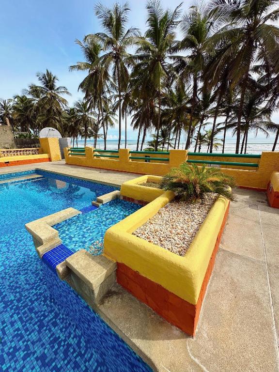 a swimming pool with palm trees in the background at Fran Tucacas playa in Tucacas