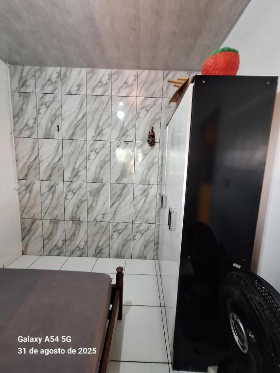 a bathroom with a marble wall and a door at Casa de Praia in Mosqueiro