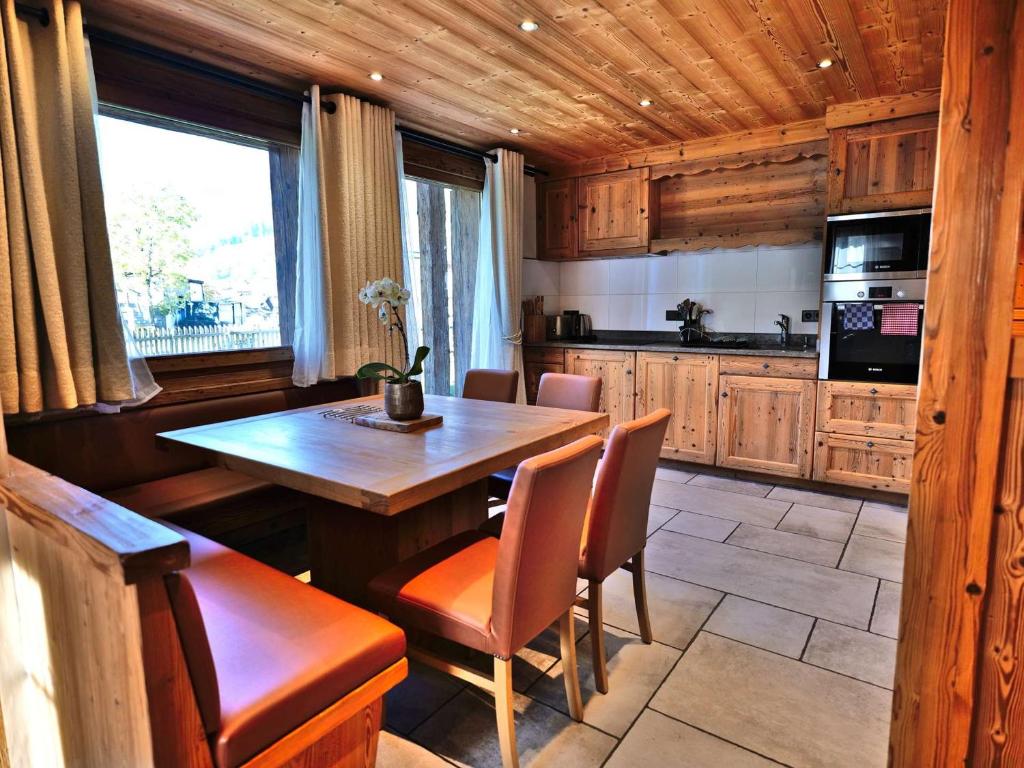 eine Küche mit Tisch und Stühlen in einem Zimmer in der Unterkunft Charmant 3 pièces rénové avec sauna et jacuzzi pour 6 pers. au Grand-Bornand - FR-1-458-107 in Le Grand-Bornand