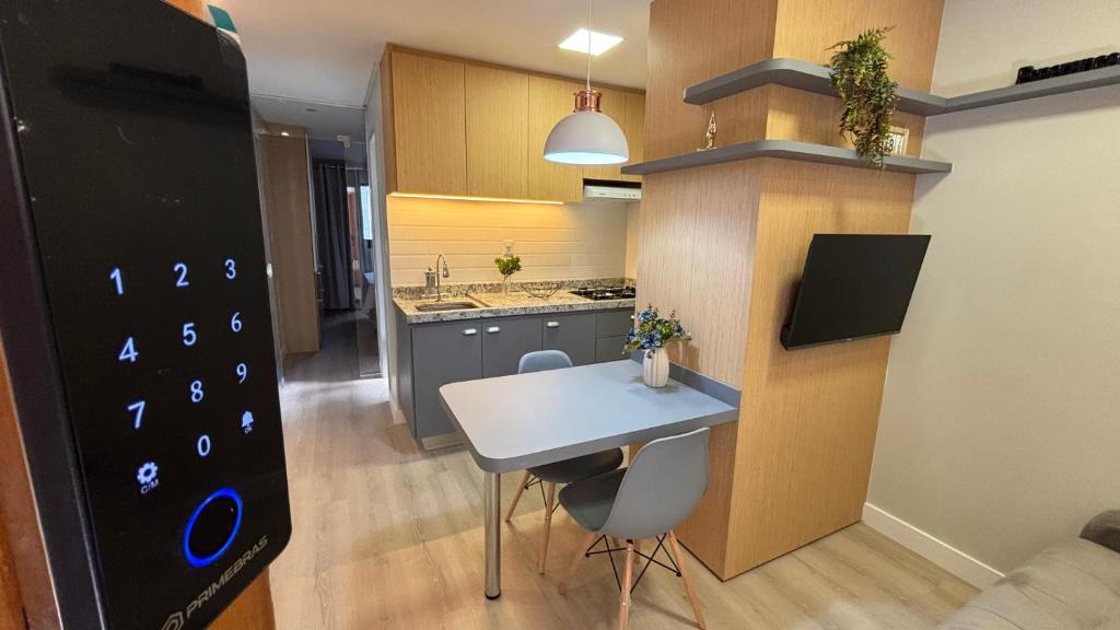 a small kitchen with a white table and chairs at Bahamas 357 - Com Garagem Coberta Gratúita in Águas Claras