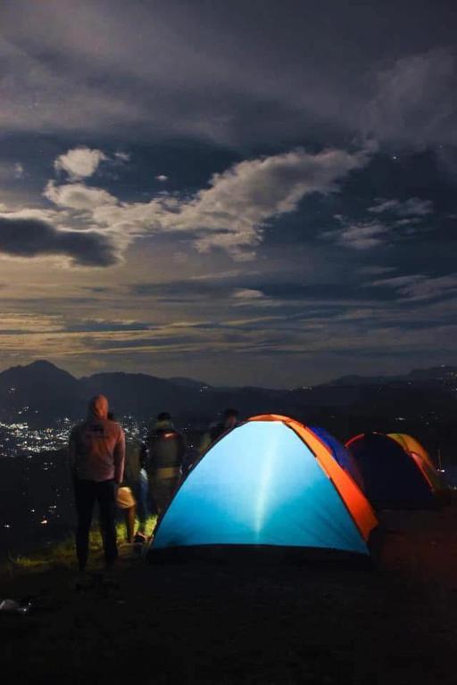 a group of people standing next to tents on a hill at narangala skycamping in Bokanoruwa