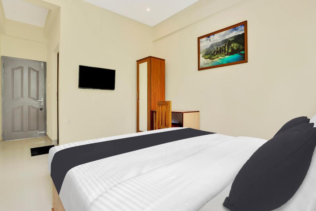 Un dormitorio con una cama blanca y un televisor. en Super Collection O Lefort LUXE by PopTavern, en Trivandrum