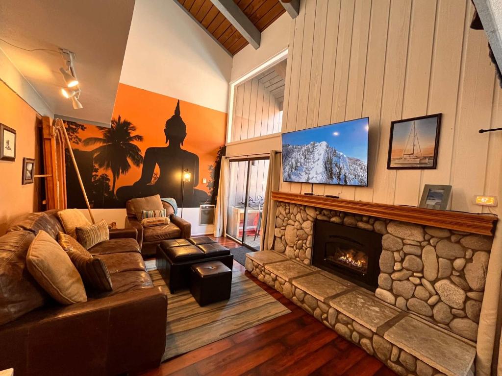 Una sala de estar con un sofá y una chimenea. en Cozy Studio with Loft at Mammoth Ski & Racquet Club, Hot Tub, Garage, 10 Min Walk to Ski Lifts, en Mammoth Lakes