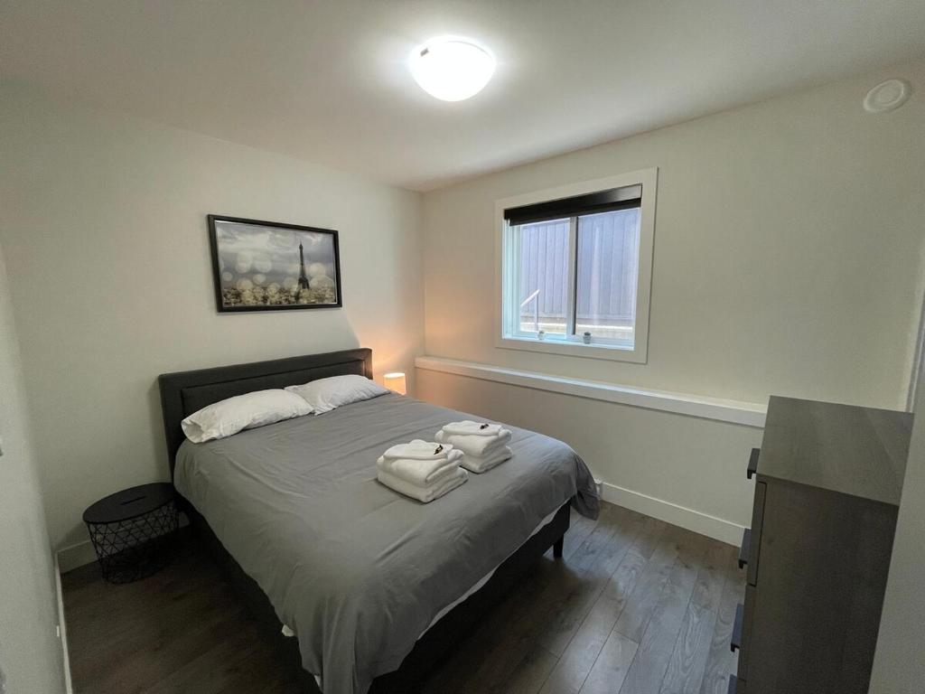 ein Schlafzimmer mit einem Bett mit Handtüchern darauf in der Unterkunft 2 queen beds with laundry, full kitchen, walk in closet in Victoria