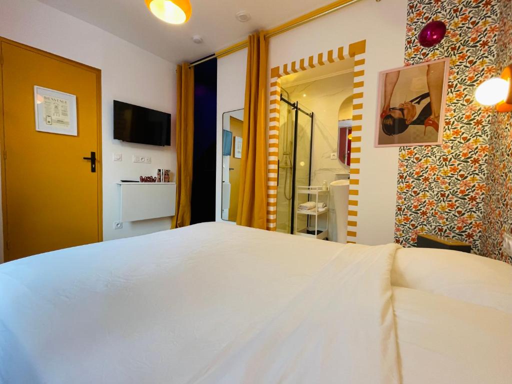 Un dormitorio con una gran cama blanca y un baño. en Love Room L Osmose Sauna hammam spa à Wimereux, en Wimereux